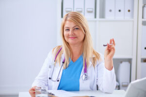 Portrait Of Young Woman Doctor With White Coat Standing